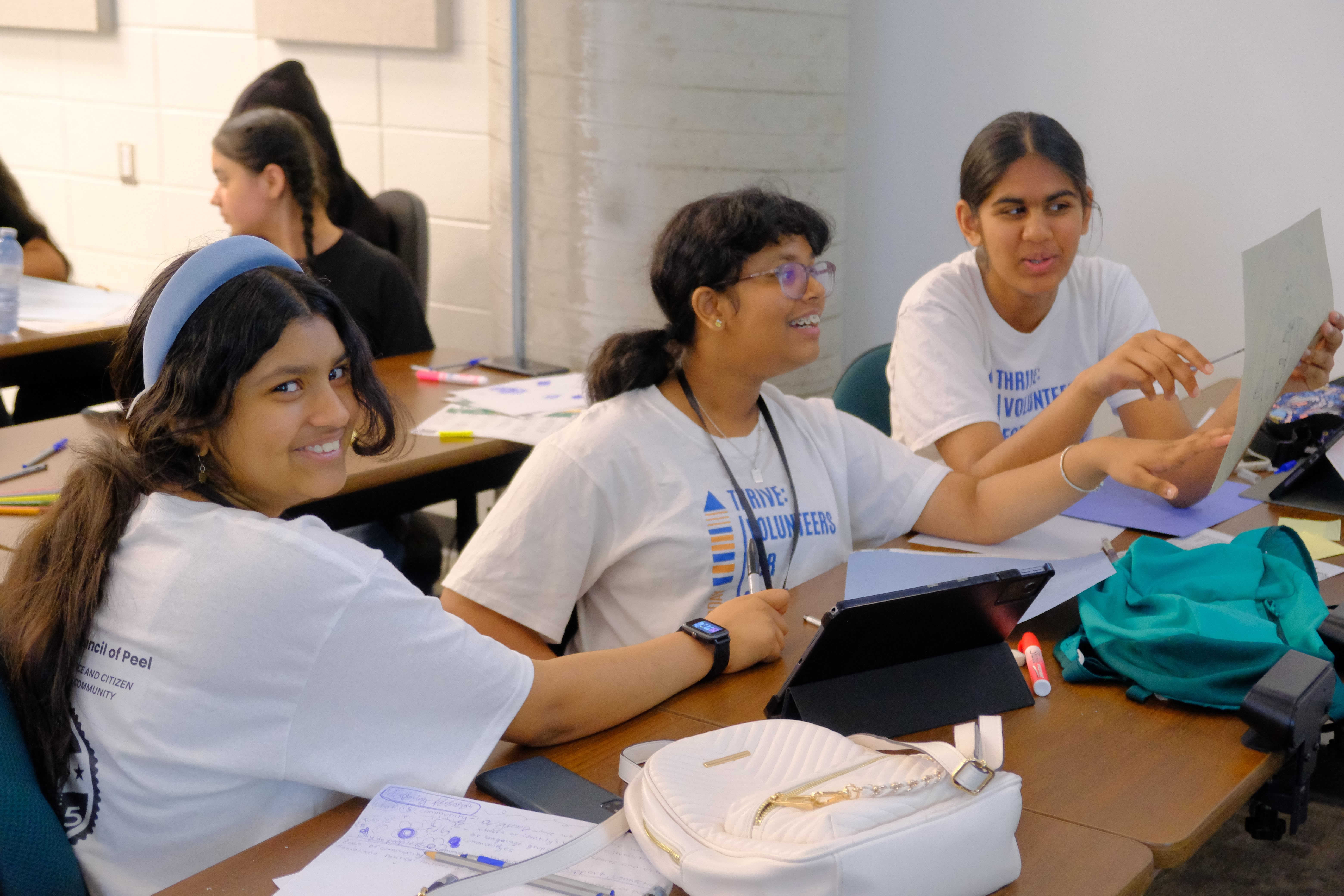 A closeup picture of youths smiling and discussing during the Learning How to Practice Community Workshop with Dr. Bethany Osborne on June 3, 2025