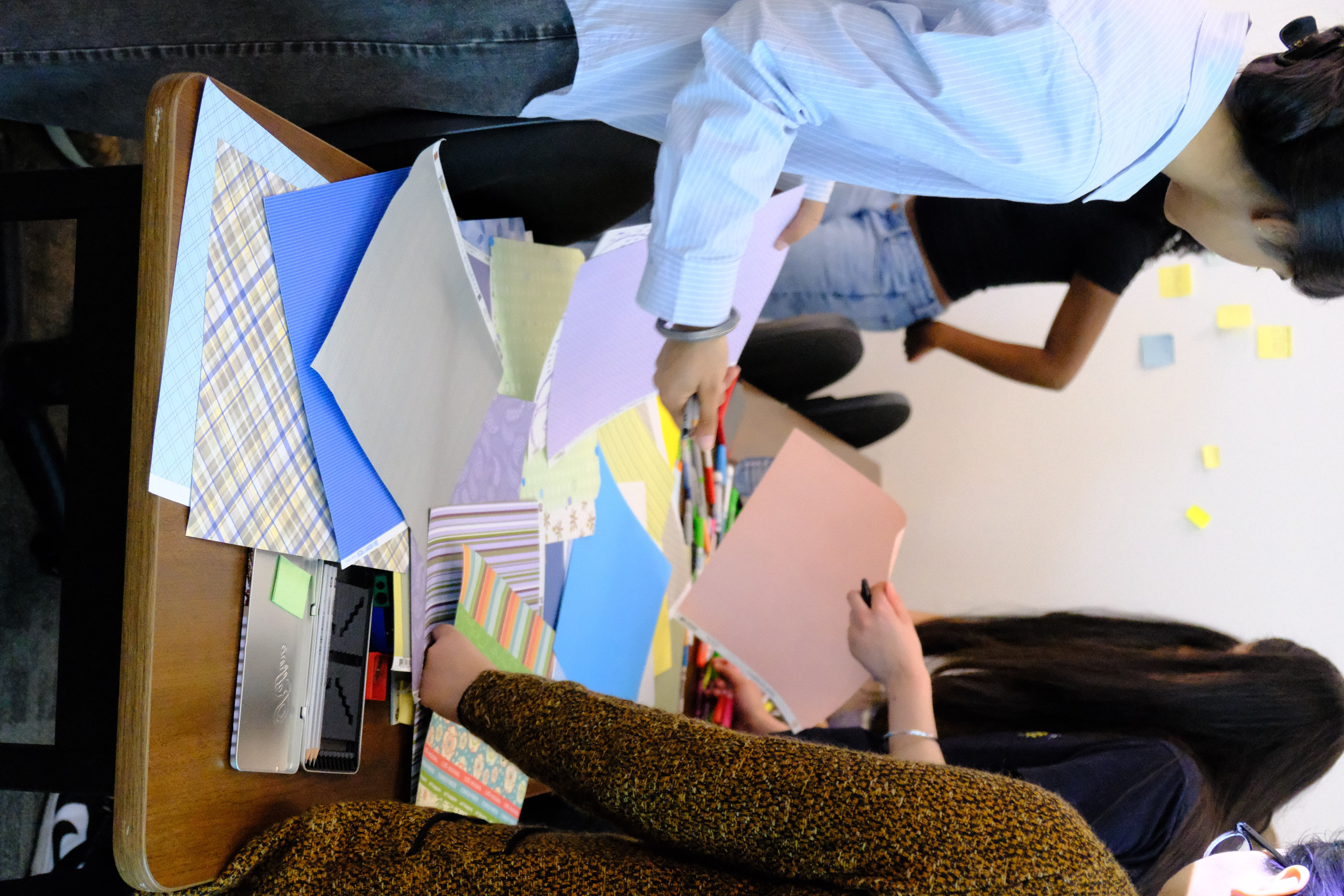 A picture of various youths interacting with various colour papers and colored markers as part of the Learning How to Practice Community Workshop with Dr. Bethany Osborne on June 3, 2025
