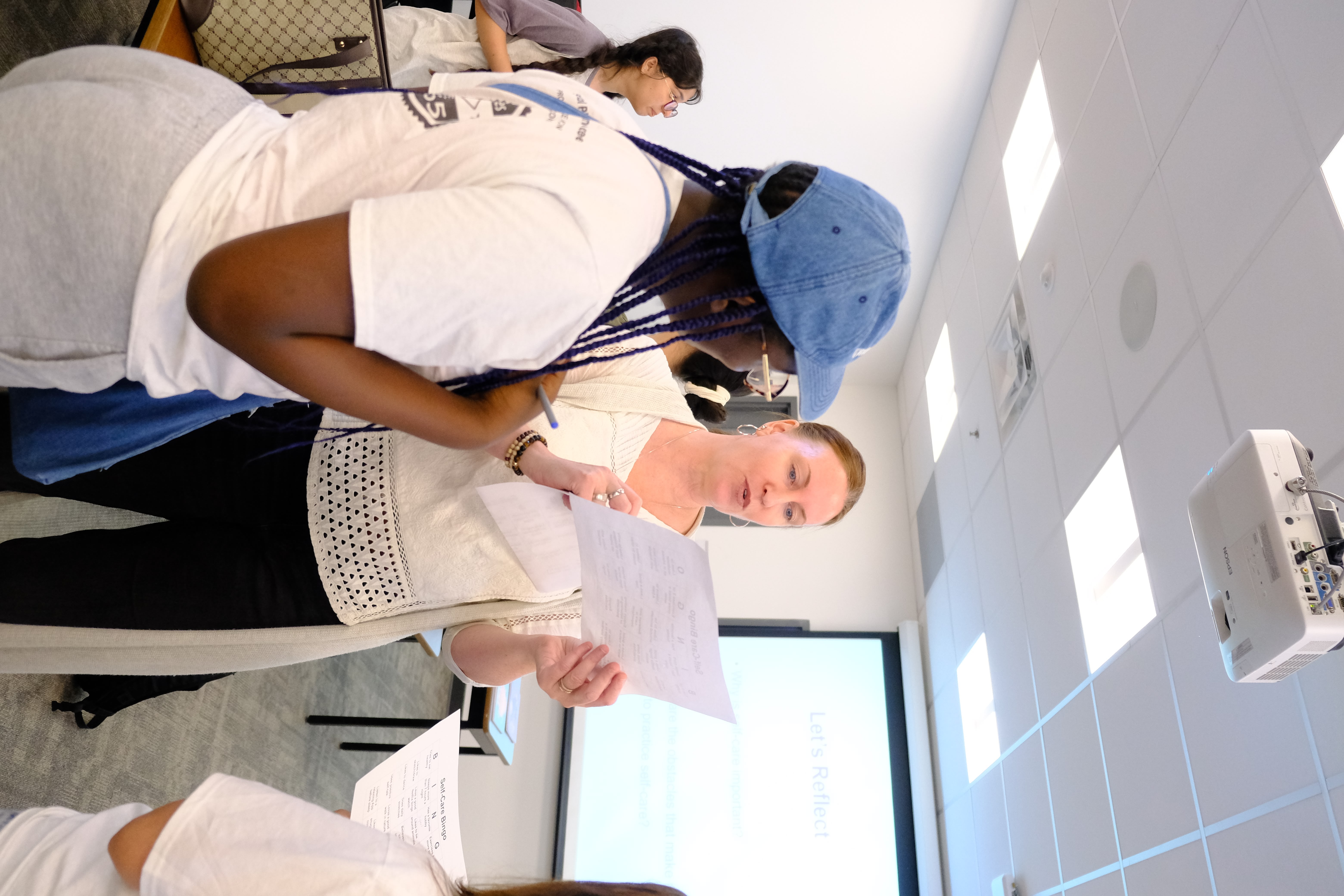 A closeup picture of SPCP staff interacting with the Facilitator during the Mental & Physical Wellness Workshop with Nicole Johnson on May 27, 2025