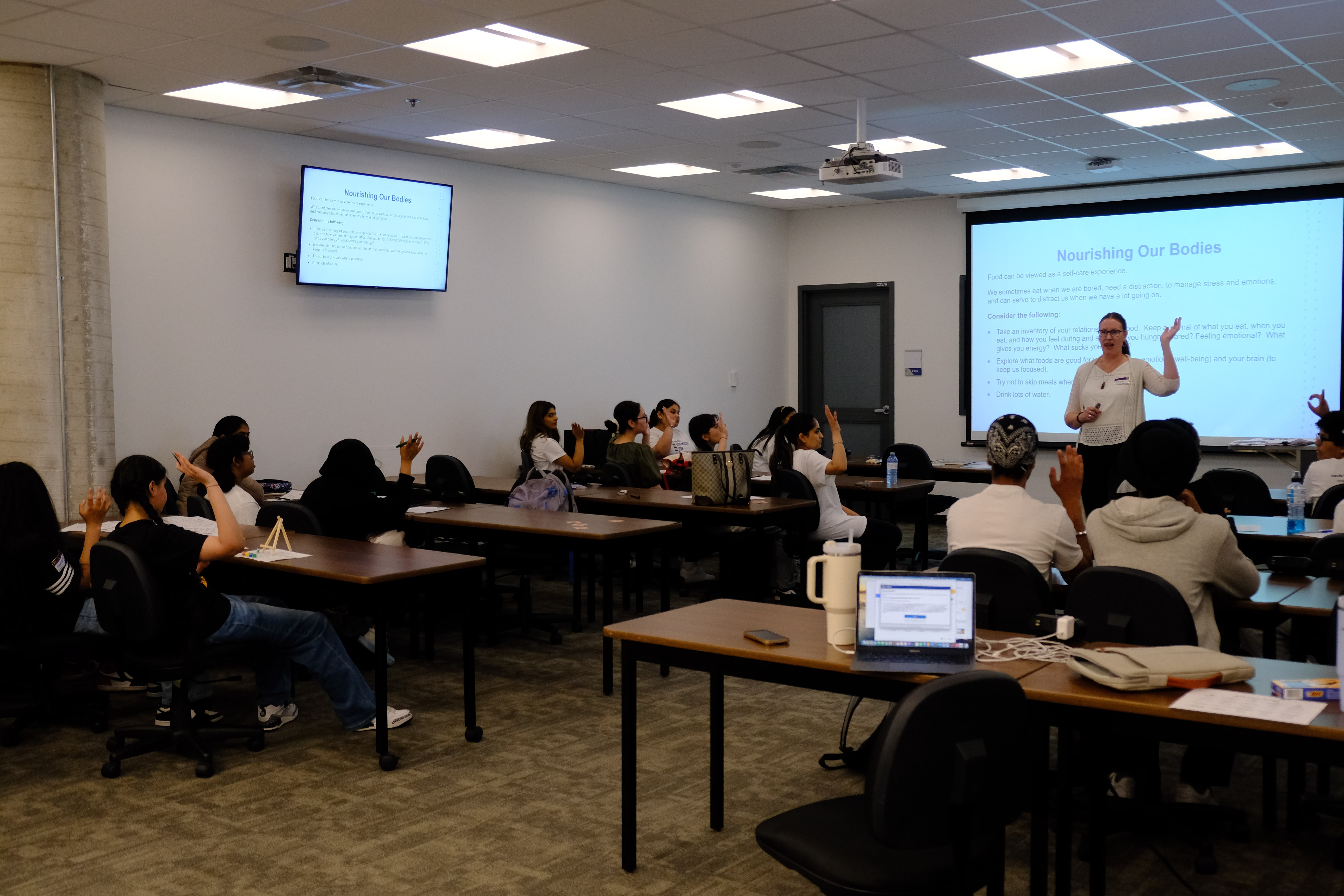 A picture of youths and the Facilitator having a discussion during the Mental & Physical Wellness Workshop with Nicole Johnson on May 27, 2025