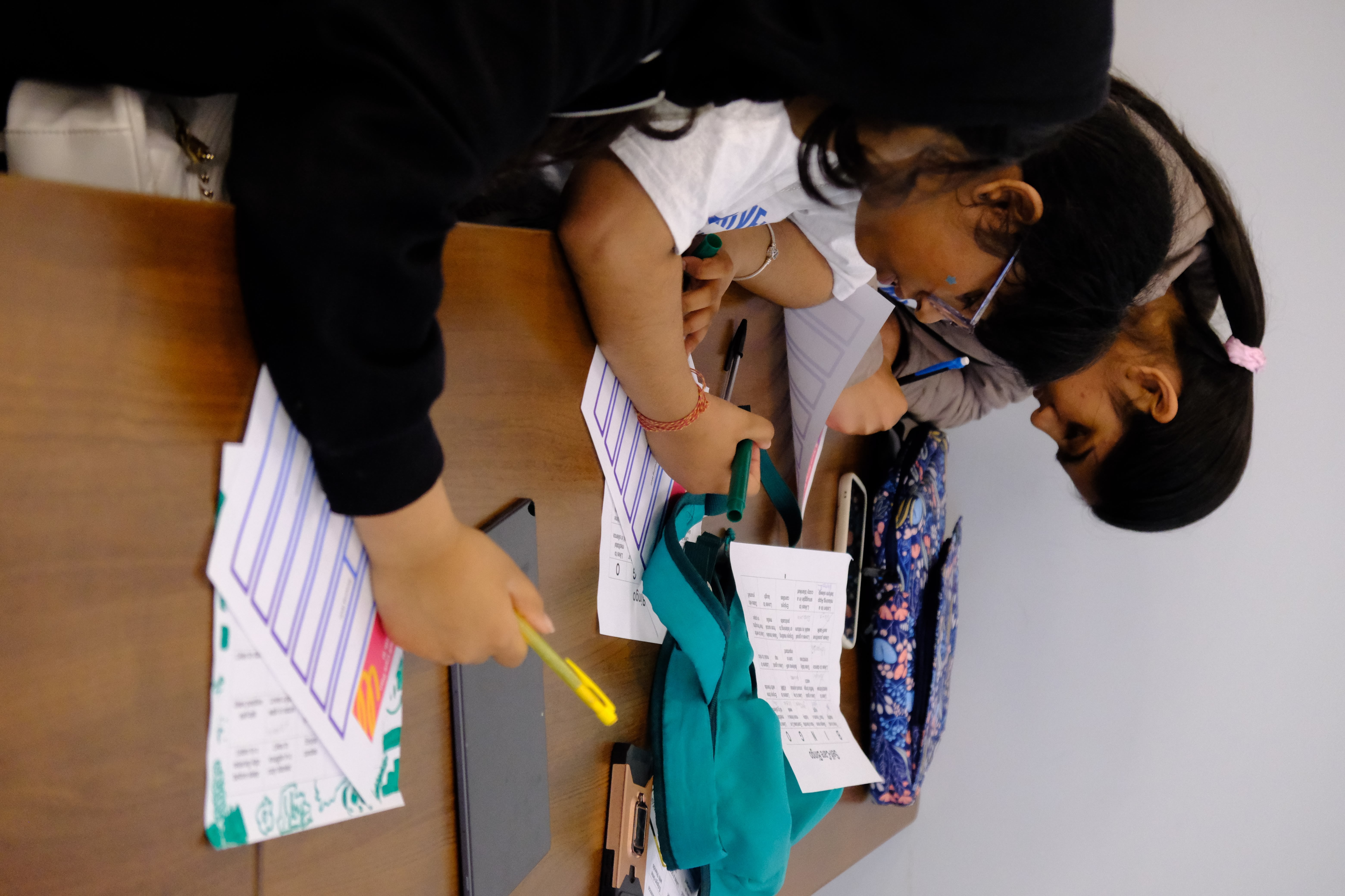 A closeup picture of couple of youths completing worksheets during the Mental & Physical Wellness Workshop with Nicole Johnson on May 27, 2025