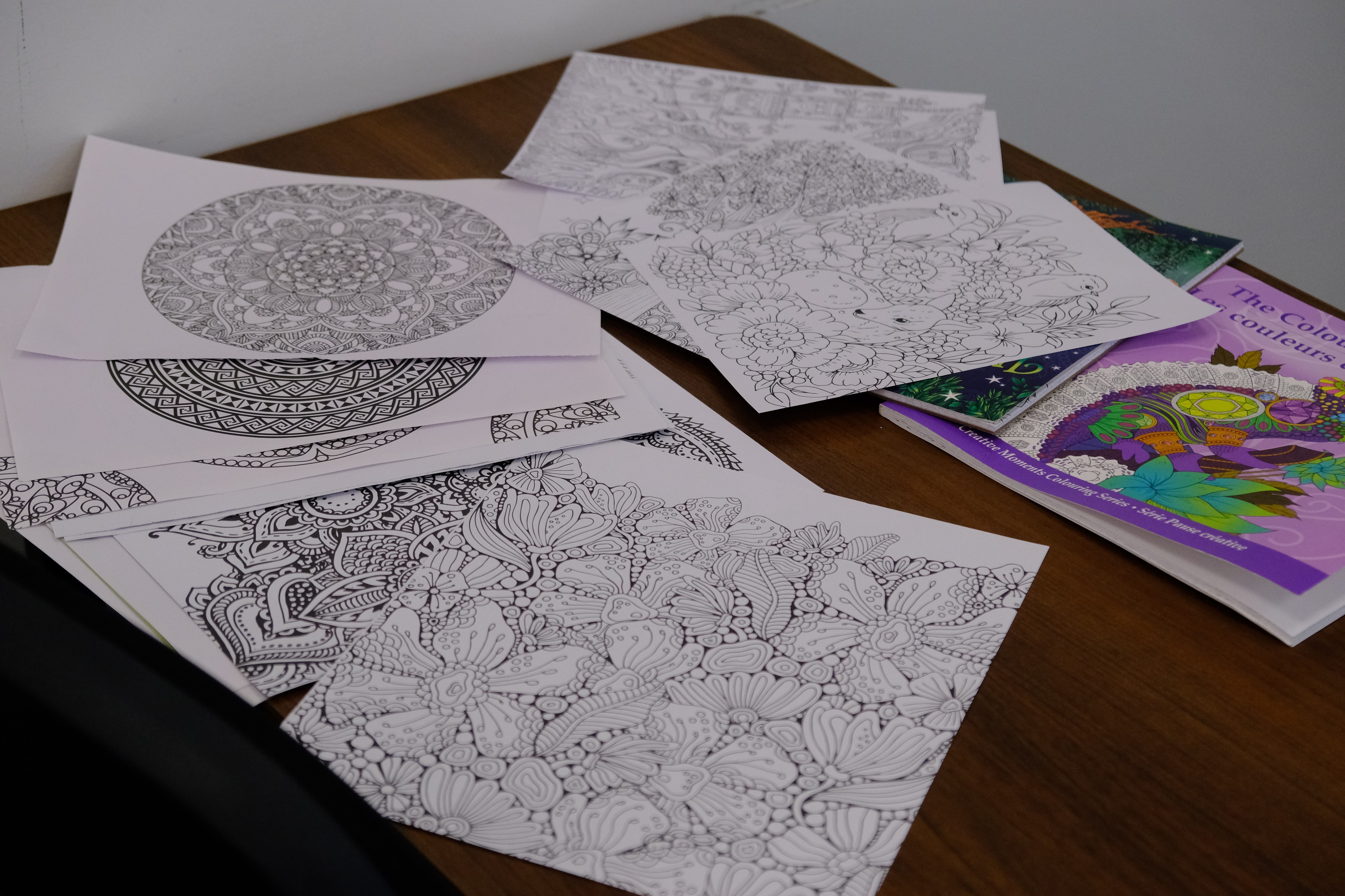 A picture of various coloring pages on a table during the Mental & Physical Wellness Workshop with Nicole Johnson on May 27, 2025