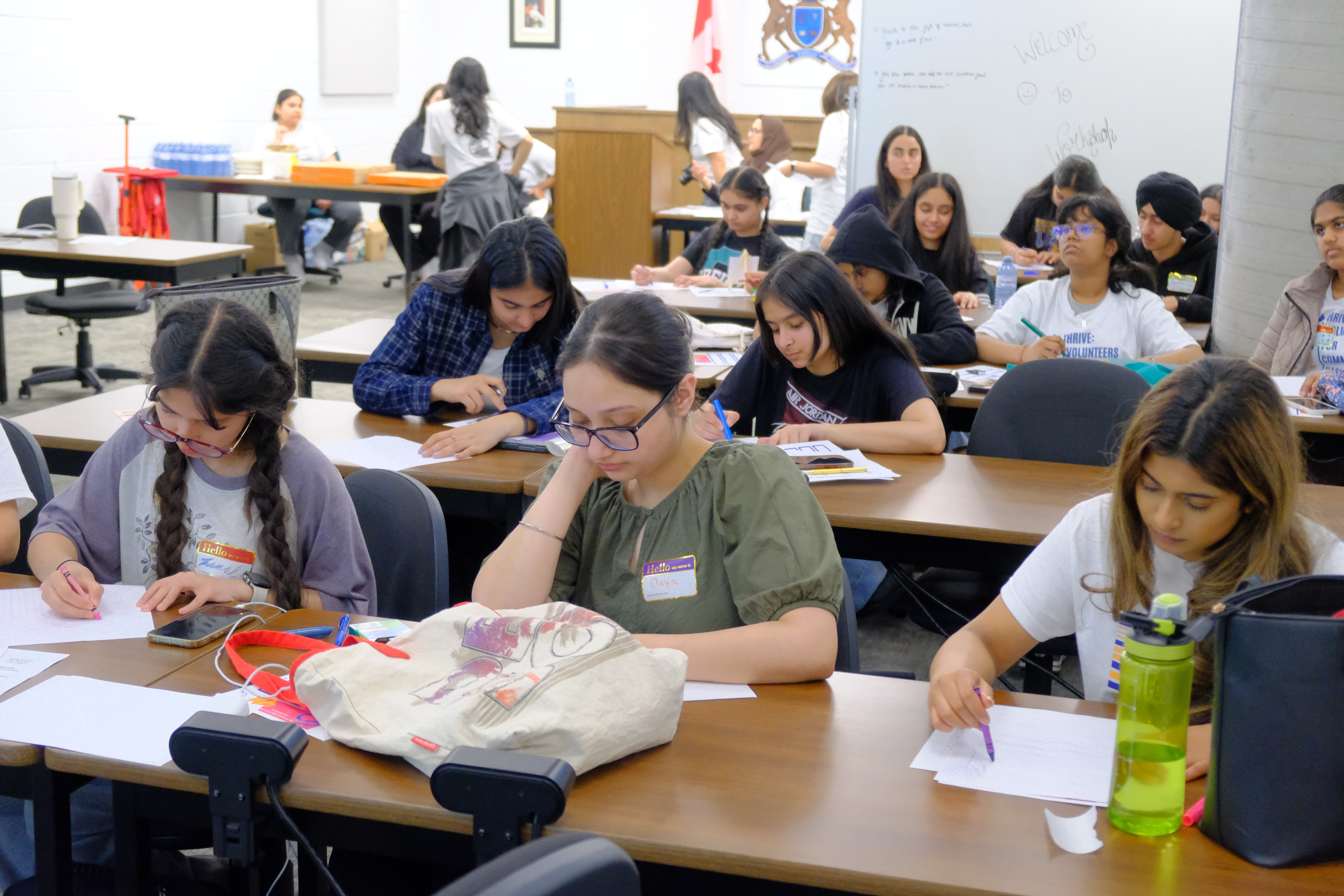 A picture of various youth focused on drawing during the Mental & Physical Wellness Workshop with Nicole Johnson on May 27, 2025