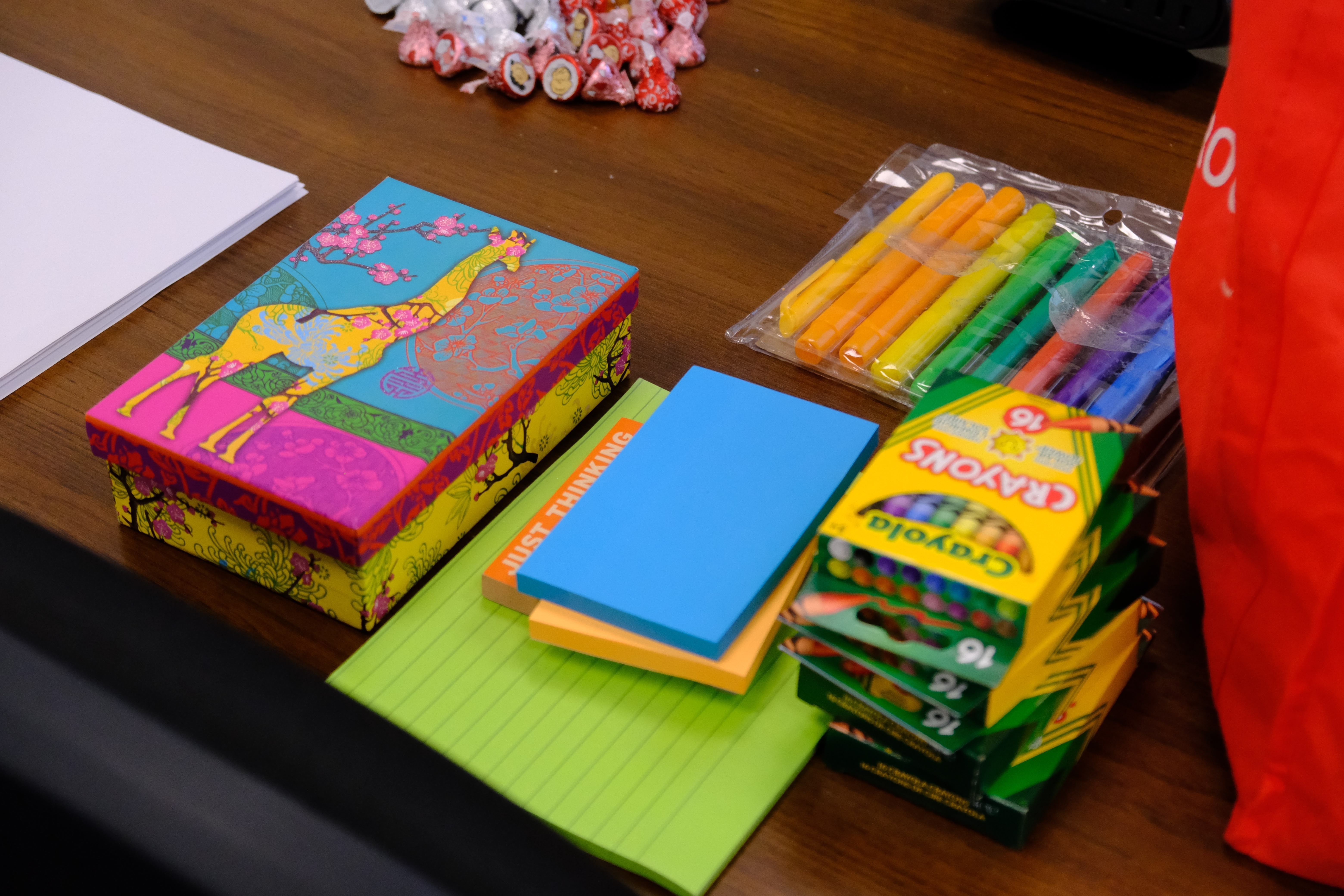 A picture of various crayons, colored markers, sticky notes and paper on table during the Mental & Physical Wellness Workshop with Nicole Johnson on May 27, 2025