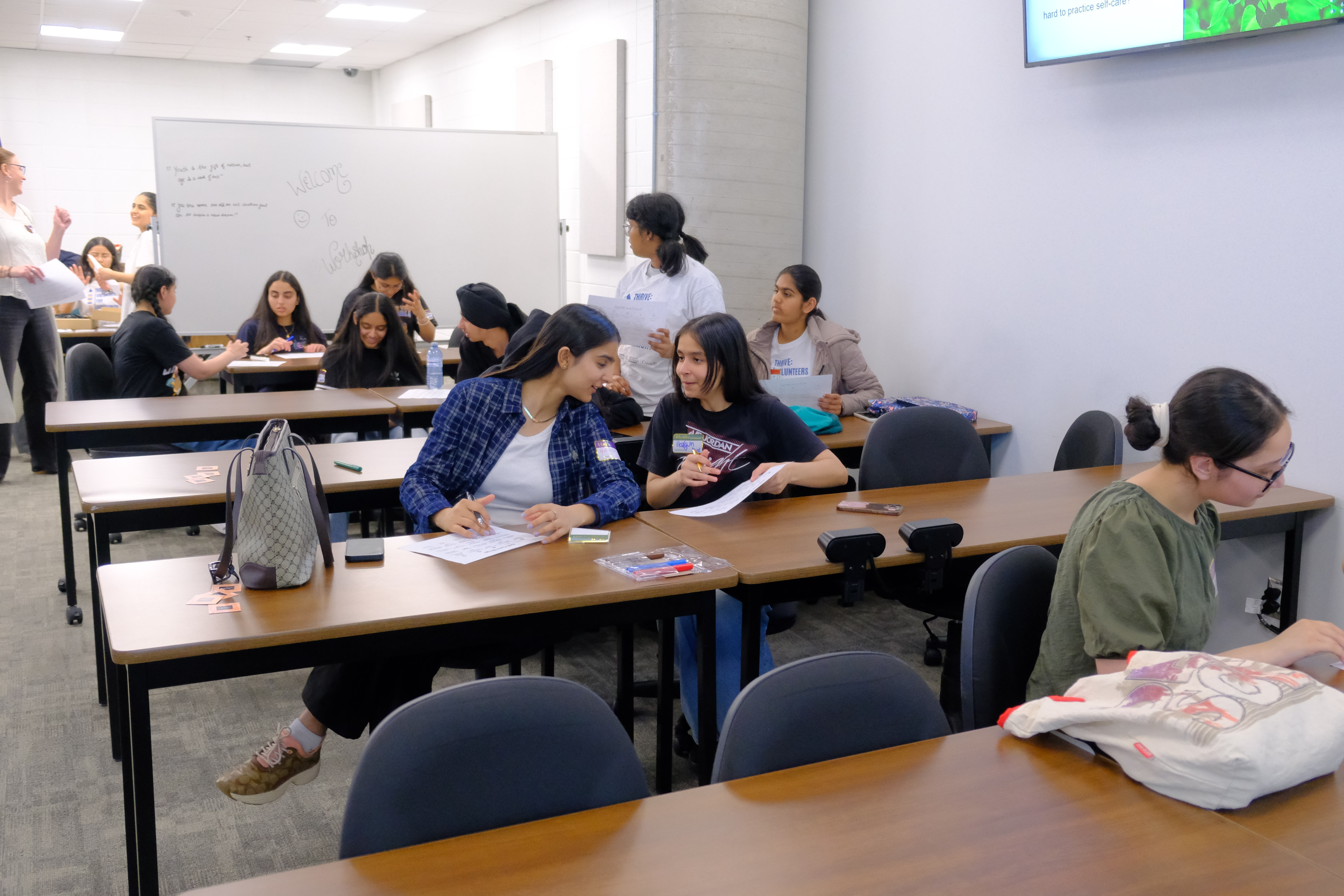 A picture of various youths and the Facilitator interacting with each other during the Mental & Physical Wellness Workshop with Nicole Johnson on May 27, 2025