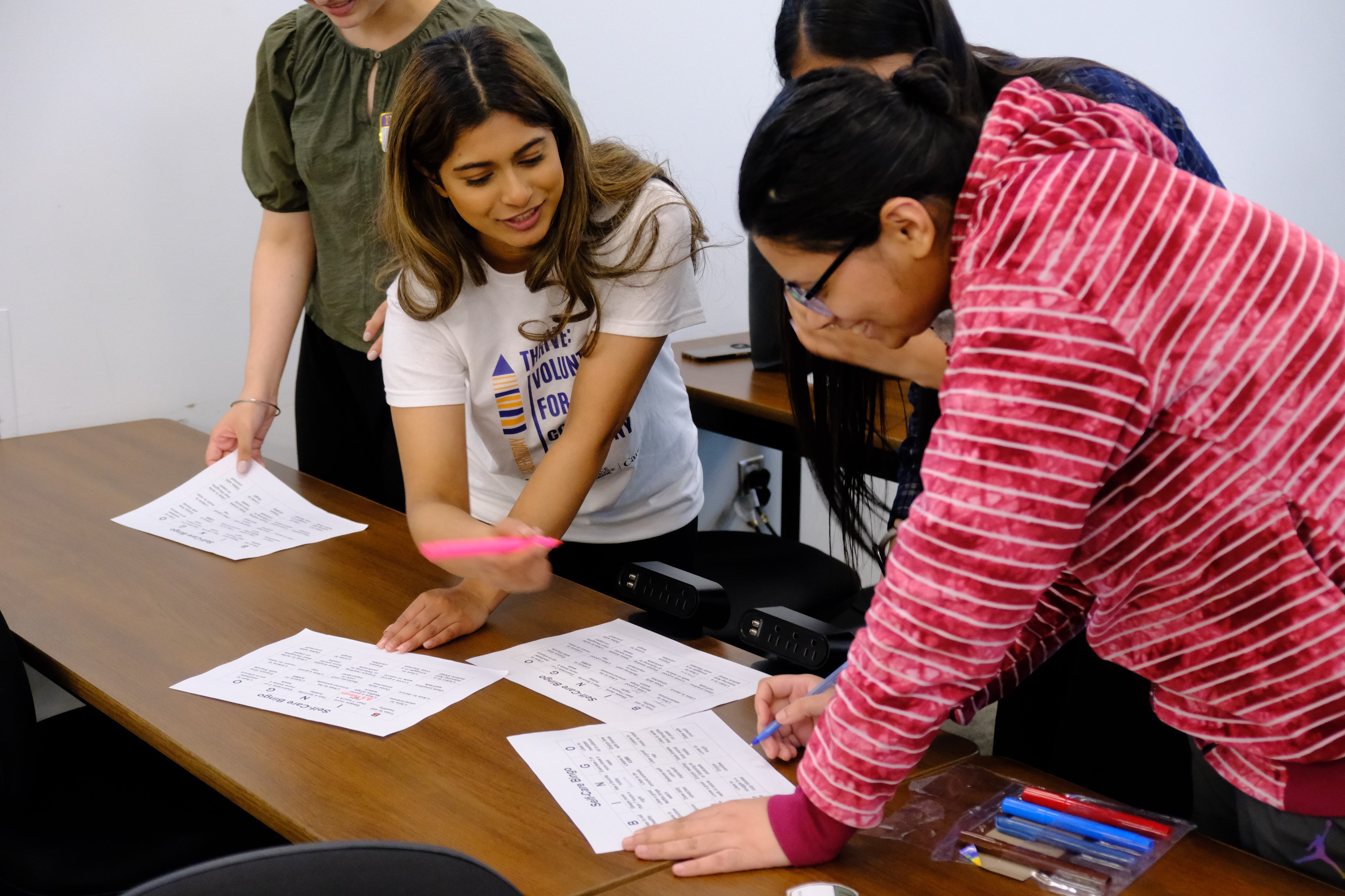 A closeup picture of a group of youths interacting with each other to complete tasks during the Mental & Physical Wellness Workshop with Nicole Johnson on May 27, 2025
