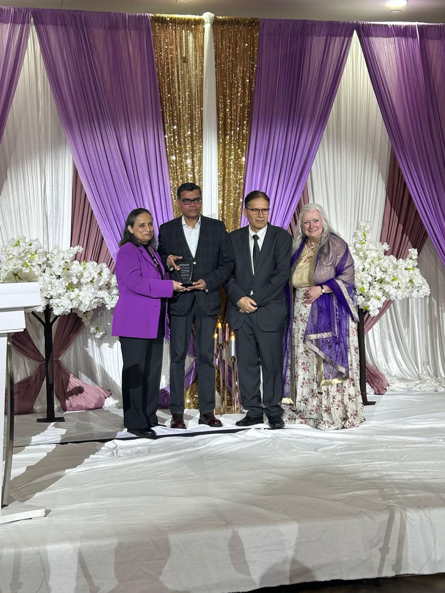 A picture of the SPCP CEO, and a board member receiving an award at an International Women's Day community gala.