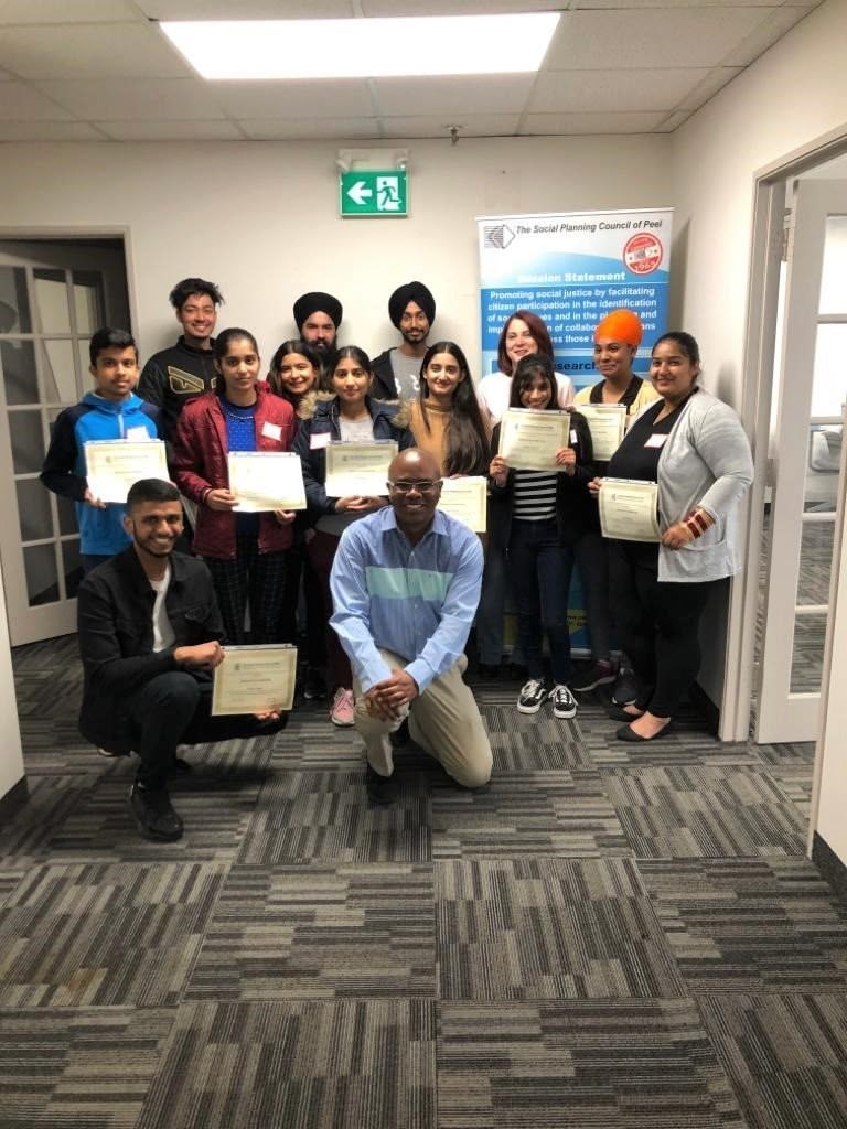A picture of youths, a facilitator and the SPCP staff at a professional skill development workshop. The youths are holding their certificates of project completion.