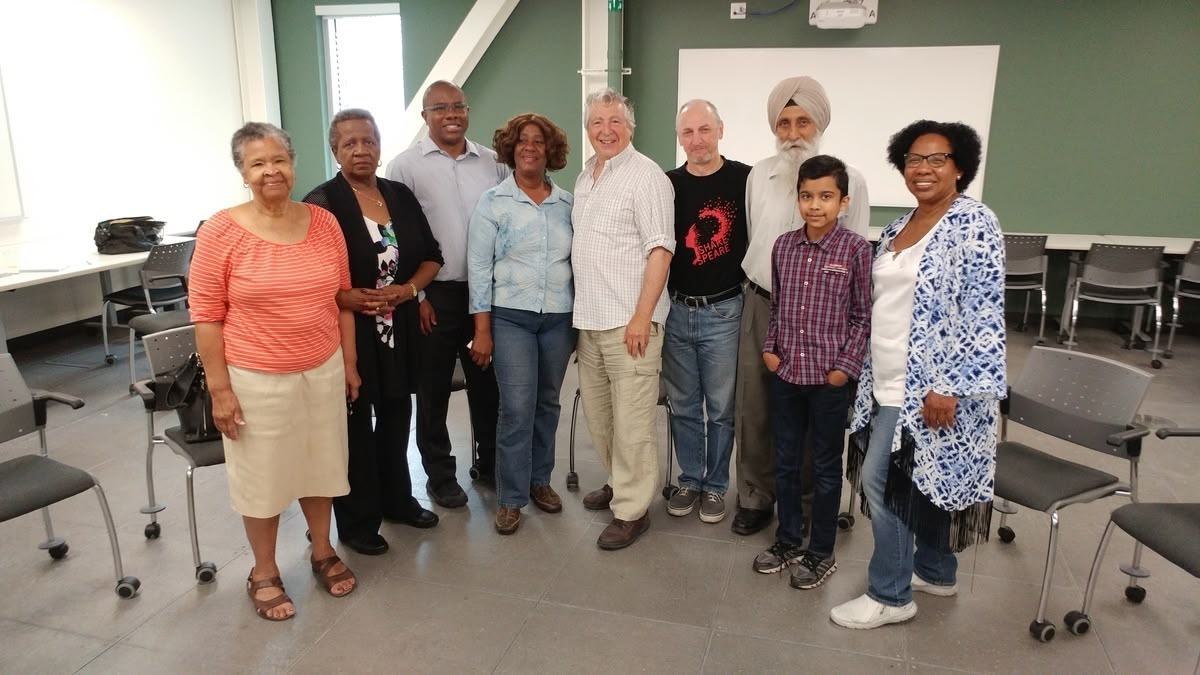 A picture of seniors, facilitators, SPCP staff and a youth volunteer at a theatre-based social wellness workshop.