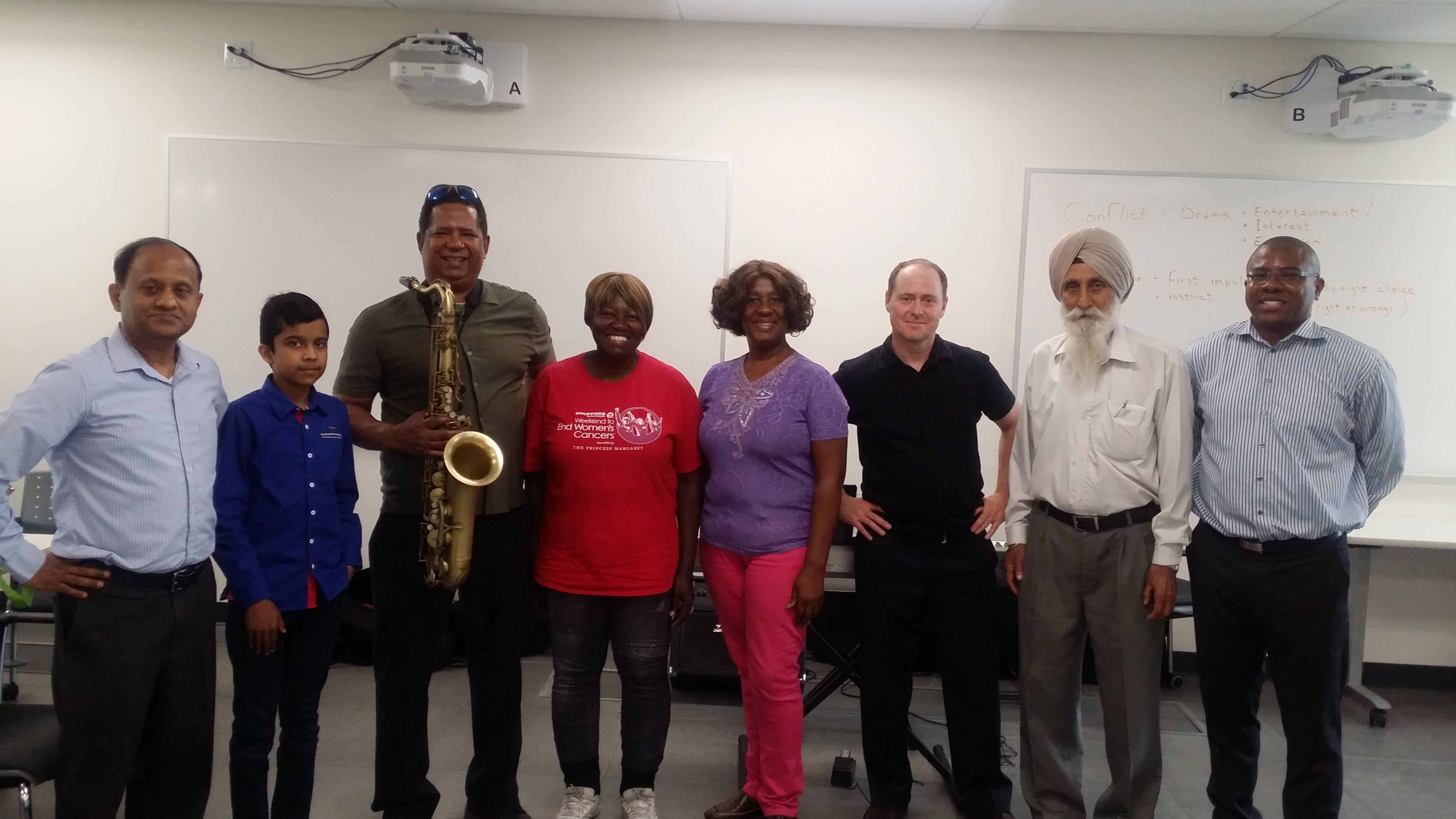 A picture of seniors, musicians, SPCP staff and a youth volunteer at a theatre-based social wellness workshop.